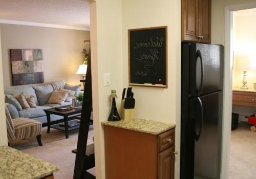 A kitchen with a black refrigerator freezer next to a doorway